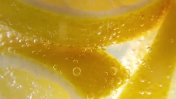 Limão fresco é adicionado a um copo de água gelada espumante, fazendo um refrescante refrigerante. Um refrescante refrigerante. — Vídeo de Stock