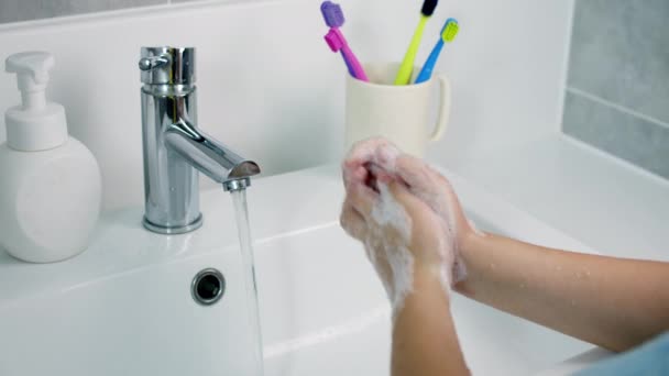 Ребенок моет руки с мылом, маленькая девочка моет руки, чтобы предотвратить распространение вируса и бактерий. Здравоохранение, базовая гигиена дома. — стоковое видео