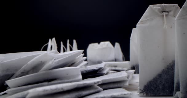 Super close-up set of tea bags on a white table on a black background. Making morning tea. Macro shooting for tea clip is suitable for culinary and culinary projects. — Stock Video