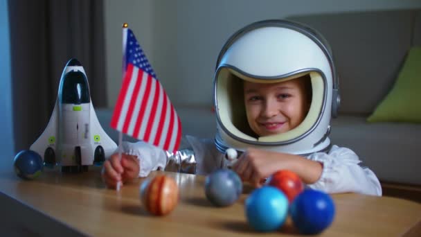 Astronot kostümü giymiş küçük bir kızın portresi. Gülümseyen mutlu bir çocuk. Kameraya bakıyor. — Stok video