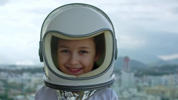 Bambino che gioca in strada con un astronauta, ritratto di una bambina di 8 anni in costume da astronauta, sorridente bambino felice che guarda la macchina fotografica, primo piano, pilota, viaggi nello spazio. — Video Stock