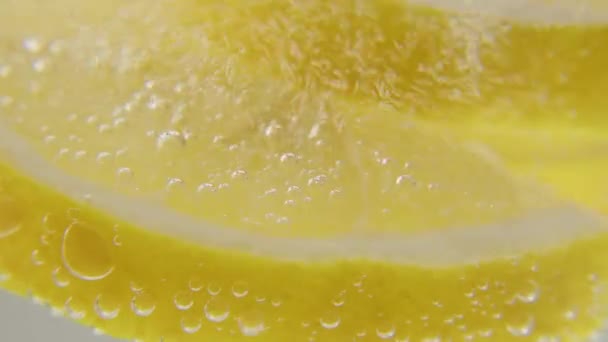 Du citron frais est ajouté à un verre d'eau glacée pétillante, ce qui en fait une boisson rafraîchissante. Une boisson rafraîchissante. — Video