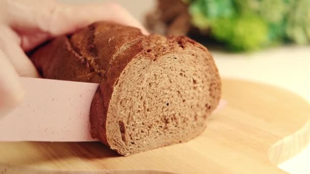 Sabahın erken saatlerinde, bir kadın ailesine sandviç yapmak için ekmek keser. Karbonhidratlar, yağ konsepti. — Stok video