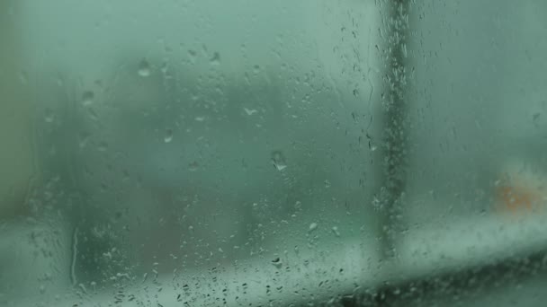 閉じるガラス上の水滴のアップ、雨、離れて行く。夏のシャワーの間に大きな雨滴が窓ガラスを打つ。4K. — ストック動画