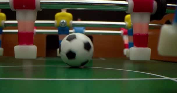 Gros plan d'amis jouant au baby-foot gros plan. Au ralenti. Profondeur de champ faible. Match de football Football sur la table de jeu. Filmer à l'intérieur du terrain de jeu. — Video