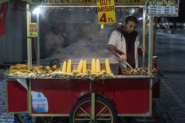ISTANBUL - 27 Aralık: 27 Aralık 'ta İstanbul Sultanahmet Meydanı' ndaki bir sokakta mısır ve kestane üreten bir sokak satıcısı. Türkiye 'de 2019