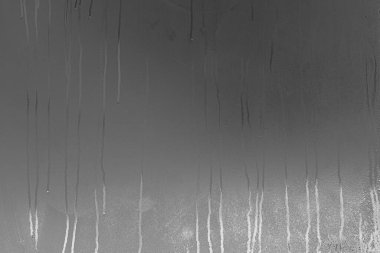 Yağmur yağan gecede buharlı ve yoğunlaşan gerçek cam pencere.