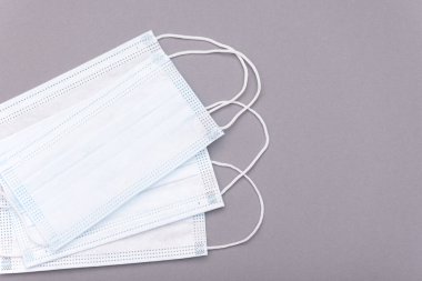 Gri arka planda koruyucu tıbbi maskeler, üst görünüm, tıbbi tema