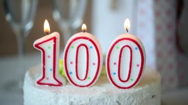 Doğum günü mumu, 100 numara olarak masadaki tatlı kekin üstünde, 100. doğum günü.