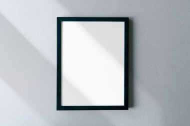 Gölgeli ve yüzeyinde güneş ışığı olan boş bir fotoğraf çerçevesi. Metin için alanı olan şablon. 