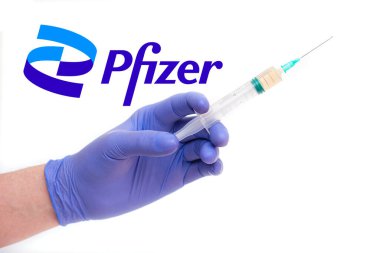 BERLİN - 23 Haziran 2021 'de Almanya' da PFIZER logotype ve şırıngayla şırınga tutan bir doktor Berlin 'de beyaz aşılarla izole edildi.