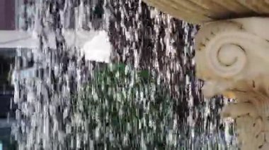 Yazın güneşli bir günde su akıntısı olan mermer çeşmenin yakınına.