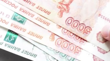 Rus parası ve pasaportu masanın üstünde. 1000 ve 5000 Rus parası ve pasaport kapağı. Video 4k çözünürlüğü