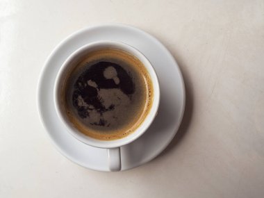 Sıcak meşrubatlı seramik bardak, ahşap masada sade kahve. Bir fincan kahveyle basit bir kompozisyon. Sabah havası. 