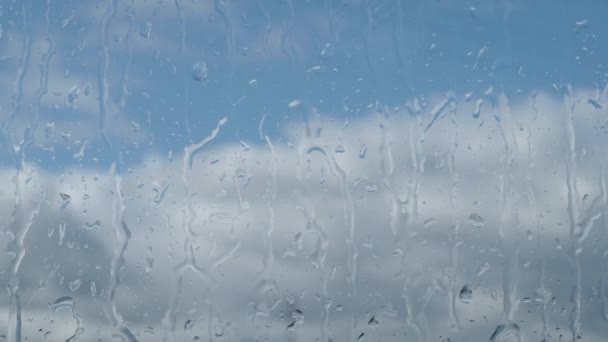 雨の日は窓ガラスの横に雨が降り 青空と雲が広がる — ストック動画