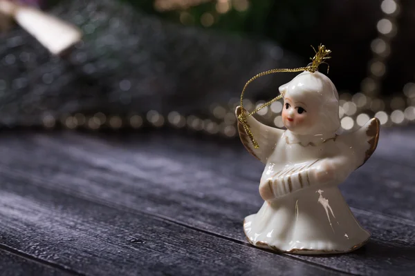 Świąteczne dekoracje, ceramiczny anioł stojący na stół z drewna — Zdjęcie stockowe