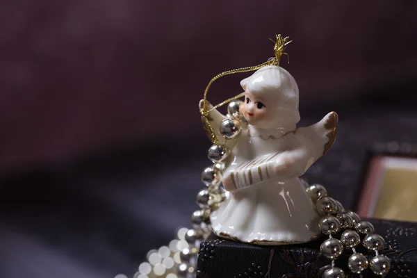 Eski kitap üzerinde duran seramik melek