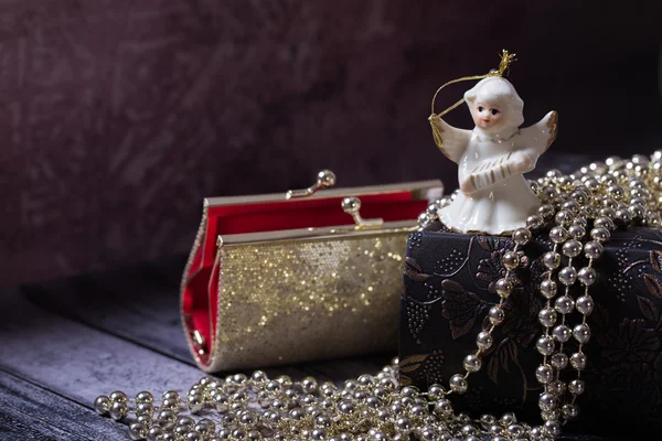 Seramik melek altın, parlak, eski kitapla kırmızı çanta tutuyoruz