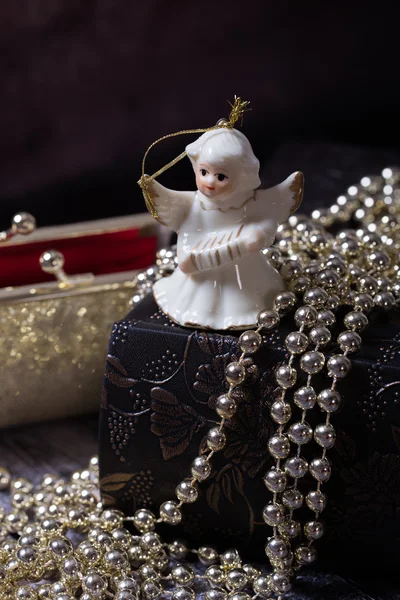 Ceramiczne aniołka stojącego na starej książki z złoty, błyszczący, czerwona torebka — Zdjęcie stockowe