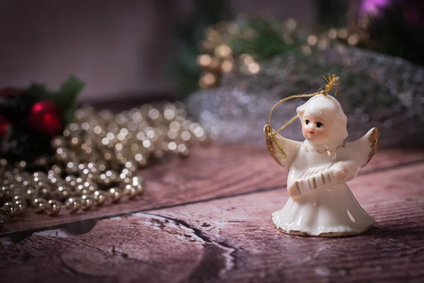 Noel zinciri ile ahşap masa üzerinde duran Noel meleği