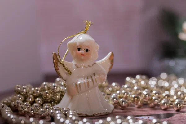 Weihnachtsengel steht auf dem Holztisch mit Weihnachtskette — Stockfoto