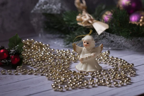 Weihnachtsengel steht auf dem Holztisch mit Weihnachtskette — Stockfoto