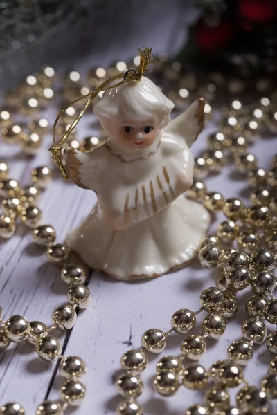 Kerstmis engel staande op de houten tafel met Kerstmis ketting — Stockfoto