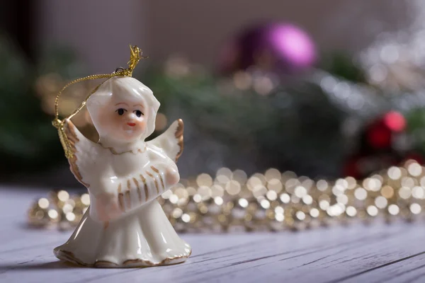 Weihnachtsengel steht auf dem Holztisch mit Weihnachtskette Stockfoto