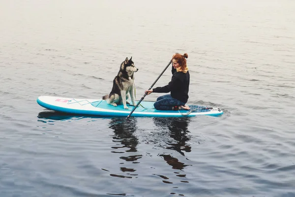 Mädchen Schwimmt Mit Husky Hund Auf Einem Brett Spaziergang See — Stockfoto