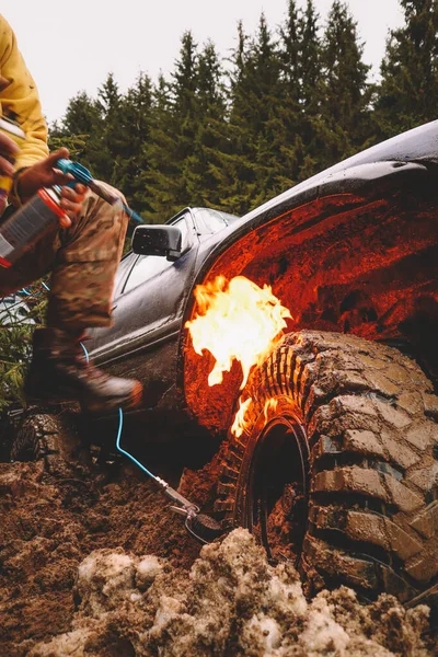 Putting the tire on the dist with gas and fire. Offroad trick. Wheel boarding in the mountains.