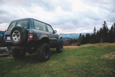 Dağlarda kirli arabalar ve tekerlekler. Lastiklerde bataklık var. Ukrayna 'ya doğru seyahatler. Karpat Dağları 'nın Manzarası.