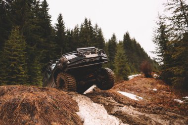 Offroad arabası dağlarda zıplıyor. Polen, bataklık ve kar. Konfor, süspansiyon, lastikler