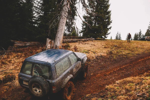 Dirty cars and wheels in the mountains. Swamp on the tires. Trips offroad across Ukraine. View of the Carpathian Mountains.