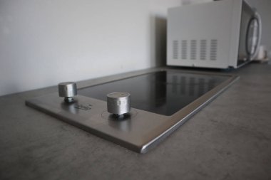 Gri tonlu modern mutfak. Lavabo ve musluk. Mutfak havluları..