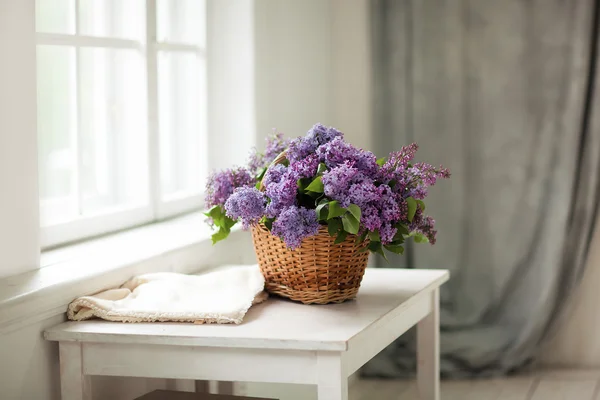 Lilac flowers in a basket. — Stock Photo, Image