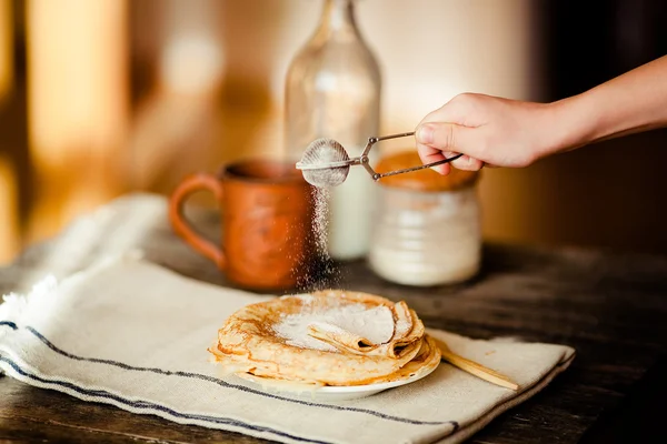 Plätera av pannkakor bevattnas med strösocker. Royaltyfria Stockfoton