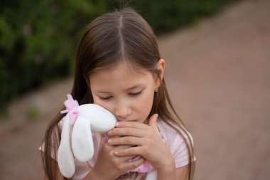 Kafkasyalı kızın oyuncağa sarılması üzücü. Çocuk dışarıda parkta yumuşak pelüş ayıyı kucaklıyor. Yalnız çocuk dışarıda kayboldu. Mutsuz çocukluk sorunları yaşam tarzı