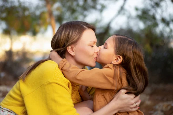 Mãe e criança andando e beijando no parque — Fotografia de Stock