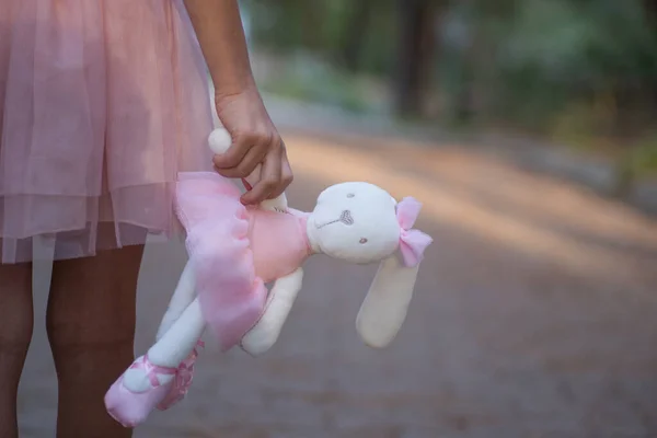 Lapin en peluche dans les mains de la fille marchant dans le parc d'automne Images De Stock Libres De Droits