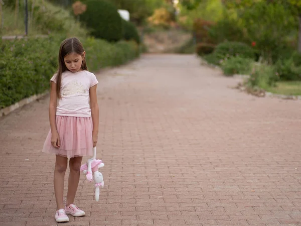 Triste fille étreignant ours en peluche tristesse seul dans le parc de jardin vert. Seule fille se sentant triste malheureux marcher à l'extérieur avec le meilleur jouet ami. Image En Vente