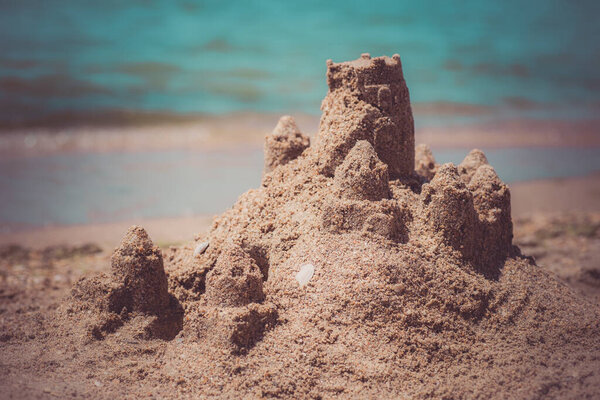 Sand castle standing on the beach. Travel vacations concept.