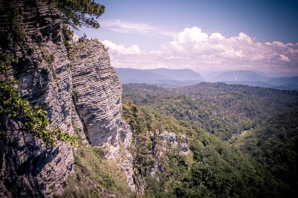 Une chaîne de montagnes non loin de la ville de Sotchi. De hauts rochers et une falaise sous eux. Eagle rocks. Forêt verte en dessous Photo De Stock