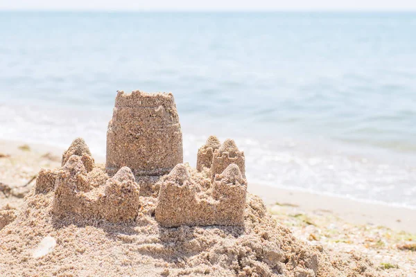 Château de sable debout sur la plage. Concept de vacances de voyage. Photos De Stock Libres De Droits