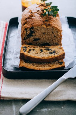 Kuru erikli kek ve siyah metal tepside tuzlu karamel ve keten peçetede okaliptüs.