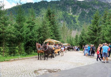 ZAKOPANE, POLAND - 03 Ağustos 2021: Tatra Dağlarında yürüyen turistler. Morskie Oko 'ya gidiyorum.