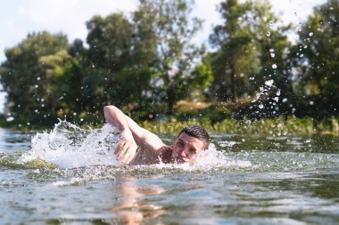 Genç adam nehirde yüzüyor..