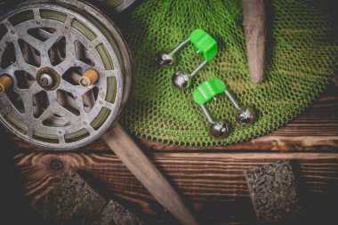 Ahşap bir arka planda eski nadide balık avlama makaraları. Bell, akvaryum ve makuha küpleri. Stüdyo fotoğrafı.