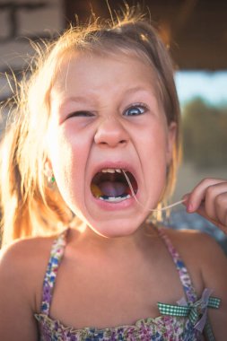 Bir bebek dişini iplik kullanarak çıkarma işlemi.