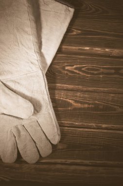 Ahşap arka planda beyaz deri kaynak eldivenleri. Sert ışıklandırmalı bir stüdyo fotoğrafı..