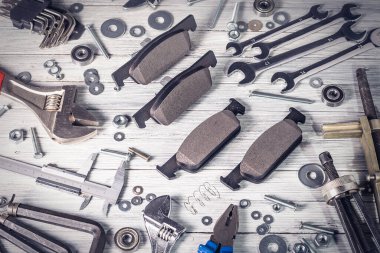 Beyaz ahşap arka planda yeni araba fren pedleri. Vignetting ile Stüdyo fotoğrafı.